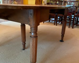 This table is soooo charming that my clients used it for their formal dinning  table with 8 antique Chippendale formal chairs.  An antique 19th century solid walnut oval drop leaf extension table with 5 legs and 4 leaves. Solid walnut five turned legs. Four solid walnut original leaves. Table is in a clean original finish. Original casters. Original custom primitive drop leaf brackets. All original parts and in good working order.  This table has a super charming primitive patch on the main table surface.