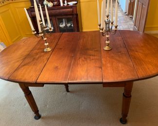 This table is soooo charming that my clients used it for their formal dinning  table with 8 antique Chippendale formal chairs.  An antique 19th century solid walnut oval drop leaf extension table with 5 legs and 4 leaves. Solid walnut five turned legs. Four solid walnut original leaves. Table is in a clean original finish. Original casters. Original custom primitive drop leaf brackets. All original parts and in good working order.  This table has a super charming primitive patch on the main table surface.