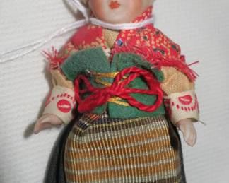Small, old, bisque doll with glass eyes. 