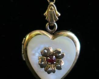 Gold filled locket with mother of pearl and a ruby. 