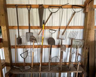 A rack of vintage and antique primitive farm tools! 