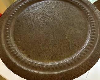 This is a unique table that folds up! That "plate" table top looks to be hammered copper!