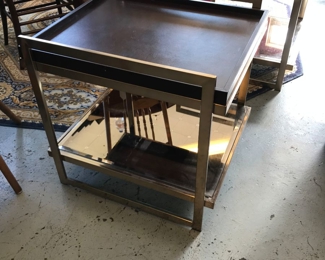 We have a pair of these beautiful Leather/Brass and beveled Mirror end tables from NFM. Stunning