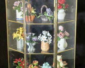Miniature porcelain flowers in glass display case 
