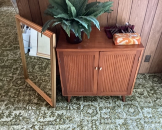 Mid Century Cabinet & Mirror. Ceramic Pot. Stainless Silverware Set by Bridal Sweet. Brick on the corner is a Brick from the Occidental Hotel