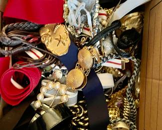 Medium size cardboard box full of belts and there are twice as many hanging on doors