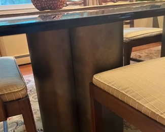 Glass, dining room table and chairs. The base of the table are metals cylinders.