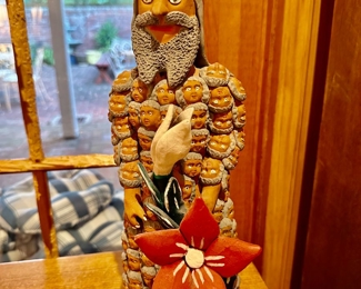 clay figure with robe of faces