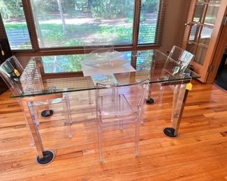 Chrome and glass dining table with 4 Kartell Ghost chairs.