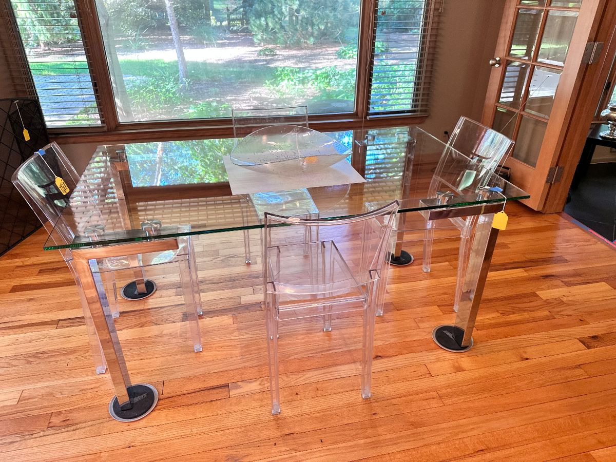 Chrome and glass dining table with 4 Kartell Ghost chairs.