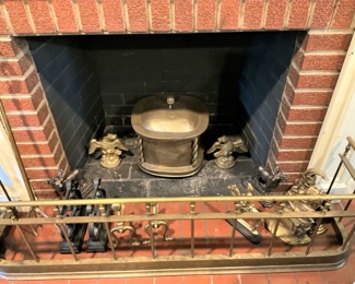 Heavy brass fire fender; various brass andirons, door-stoppers, and bookends