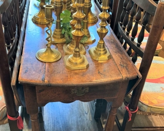 Antique drop leaf table; many brass candlesticks