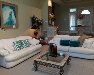 Two white International Furniture sofas, coffee table, decor and art.