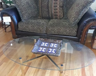 Vintage brass base and glass top coffee table, and leather loveseat.