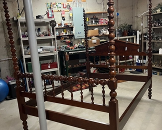 Two antique four poster beds set up in the unfinished basement