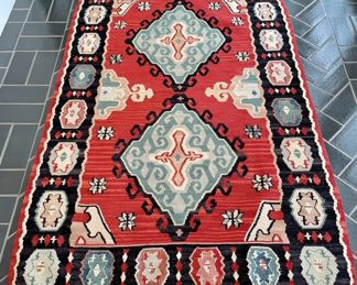 SOLD: approx 3.5' x 5'; Rug #3; kilim wool rug with burnt red base color trimmed in black with varying accent colors