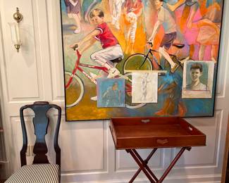 Dining Room:  One of a pair of armless chairs is to the left of a vintage tray on stand.  The original art is unsigned and measures 61" x 61." 