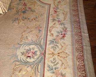 Living Room:  A large fine quality hooked area rug has a floral design [with a center oval medallion] and subtle pastel colors.  It measures 13’  3"  x  11'  7."