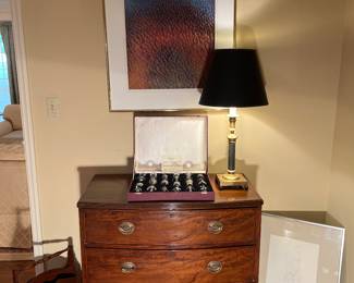 Family Room:  A signed/numbered abstract piece (1978) by artist Dennis Olsen hangs above an antique bow-front three-drawer chest (35” wide x 19” deep x 36” tall). The lamp and liqueur set (see next photo) are also for sale.