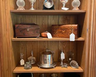 Den:   The fourth section shows CAVAN crystal baseballs near two signed baseballs (one undated by Bob Forsch; one by Ken Forsch [1979] AND Bob Forsch [1983]; a vintage unicorn lighter; and ashtray.  The second shelf: an antique rosewood tea caddy in a sarcophagus design and a Victorian Tunbridge inlaid box.   In the center of the boxes is a replica Greek geometric round lidded box.  The third shelf: glass paperweights; crystal perfume bottle; an 18th century Toddy Lifter; a silver-plate sugar shaker; and a silver-plate biscuit caddy.  The lower shelf has a faux pearl  necklace with 14K gold flower (a closer photo follows);  six silver-plate mint julep cups on a silver-plate galley tray; and a turquoise necklace.