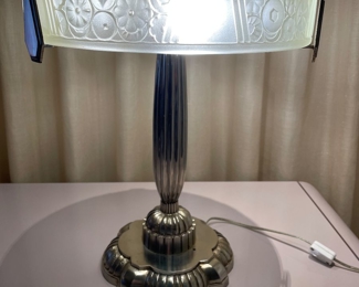 $750.  Art Deco table lamp; 14”diameter glass shade; 18”H and base is about 8” diameter; original from 1920s and heavy; chrome base shows some patina has aged and there is a small unexplainable hole on the base, but it remains a stunning original Art Deco lamp.