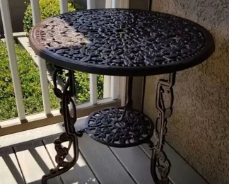 Cast iron decorative round table 25" (round) by 26" (h) with a lower shelf below.