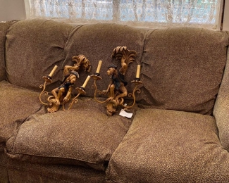 Leopard covered couch and wall sconces