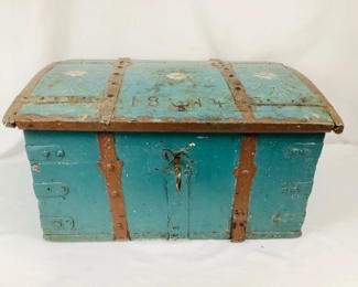 JIFI100 Antique 1814 Wedding Chest: This is a primitive antique wedding chest with the date of 1814 painted on it. It's covered in a dark teal green base coat, with brown trim adorned rustic floral designs. The chest is reinforced with iron bands and comes with a large key to lock and unlock chest. The lock is in working condition.

