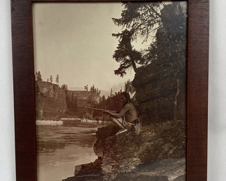JIFI103 Original R. H. McKay Photograph Waiting For The Whiteman: This is an original wood framed photograph, titled 'Waiting For The Whiteman', by R.H. McKay. This antique black & white photograph features a native man in traditional garb, holding his rifle next to a river within a steep sided gorge, intently guarding his land from intruders.&nbsp;
