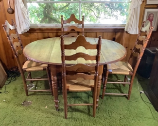 JIFI201 Antique Table Chairs: Antique table with two folding ends. Looks as though there should be an additional leaf, however we weren't able to find one, when photo's were taken. Comes with four, 4 ladder chairs, dating from the late 1810's. All have been re-caned All four legs are on small working wheels. Table and chairs show wear with minor scratches, compatible with age.
