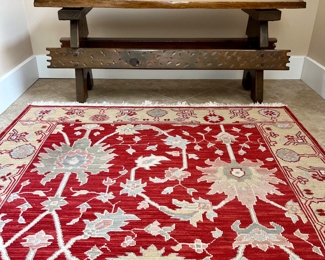 PINE BENCH AND UP CLOSE OF RED FLORAL AREA RUG