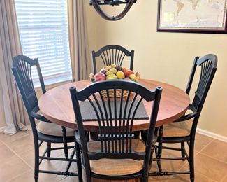 48" round dinette table with 4 arm chairs.  The table's height is adjustable, and the base is unique.