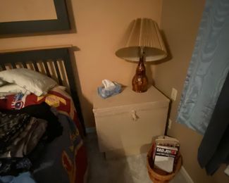 Wooden lamp base sitting on wicker storage chest