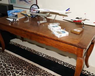 Antique table with a collection of die cast Concordes and Mooneys, as well as other planes. 