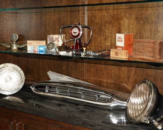 There are several vintage car parts; including grills, headlamps, steering wheels, and even a RARE flying Boyce motometer radiator ornament.