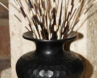 Hammered black vase with several porcupine quills