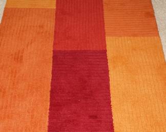 Varying shades of orange wool floor rug