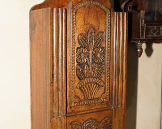 There are several antique salt boxes and wall utensil holders for sale