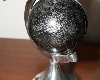 Silver globe with plane flying overhead