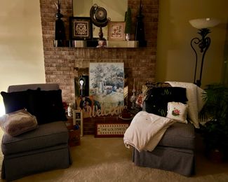 Framed prints and handmade cross-stitch patterns, chairs, handmade crocheted blanket, pillows, lamps, and decorative items