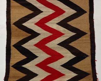 A NAVAJO ZIG ZAG RUG. AND OLDER PIECE. 3' X 4'2". Condition: one end frayed, small hole on other end. Some color run