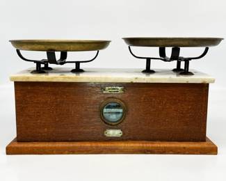 Antique August Sauter Balance Scales in Wooden Case with Marble Top | Sold by Central Scientific Company, Chicago | Brass plate at the front center of the case is signed with August Sauter Hallmark and "Made in Germany." Silver plate at the lower center of case inscribed "Made by August Sauter, Ebingen, Germany for Central Scientific Company, Chicago | Includes 2 brass plates | Approx. Size: 9" H x 17.25" W x 8" D.