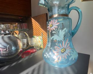 vintage Fenton blue glass large water pitcher has hand-painted flower design on body and crimped top rim.