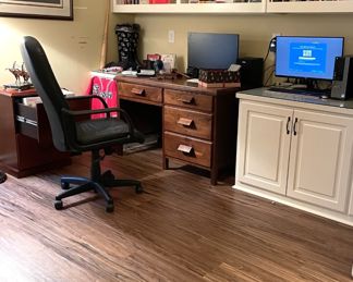 wooden desk, computer monitors, baseball bat, rolling black desk chair