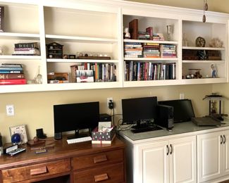 books, decor, curios, desk lamps, various monitors,