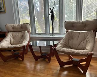 Pair of Odd Knudson leather upholstered  "LUNA" high back lounge chairs and Odd Knudson "LUNA" glass top side table. In window:  Tom Corbin bronze sculpture "Renee" with C.O.A., measures 43" 14" x 17'. 