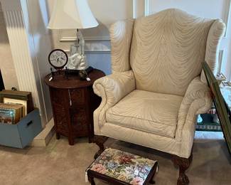 Oversized white wing back chair. Foot stool and carved Asian table with a pair of carved lamps