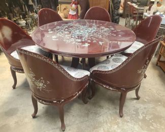 Extremely rare Dining Room Set consisting of a round table with 6 chairs. The set was made in Indonesia of extremely rare rosewood and all pieces are beautifully inlaid with mother of pearl. The table also has a glass cover to protect the table itself. In excellent condition, as pictured.