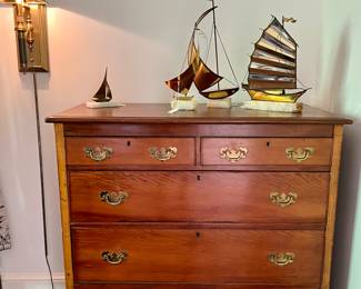 Collection of MCM copper boats sits on this 5 drawer antique chest