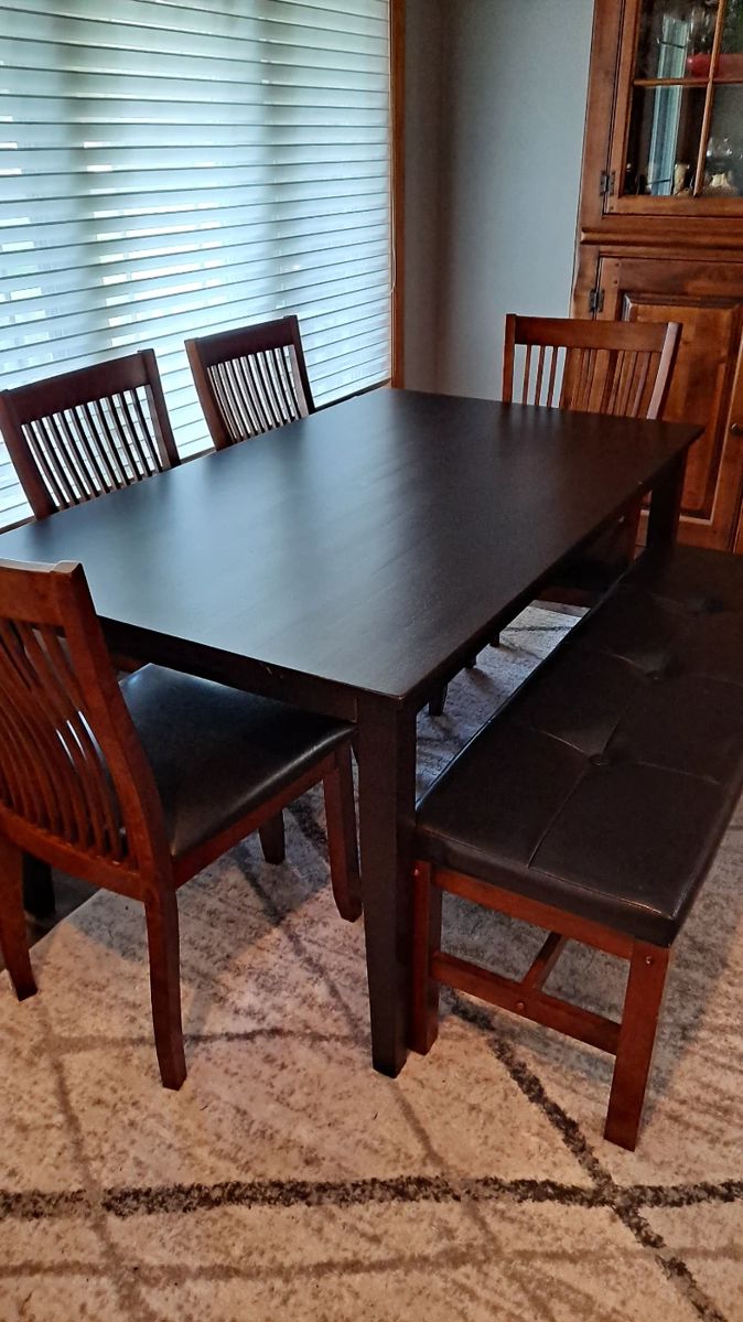Stained Black Wood Dining Table with Four Wood Chairs and a Leather Covered Bench; Decorative Area Rug